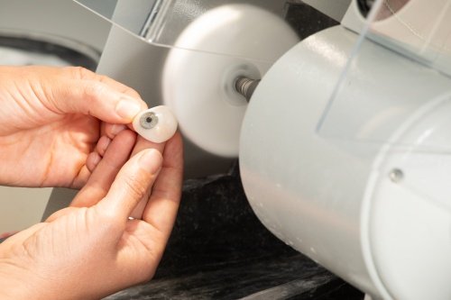 ocularist polishing eye during prosthetic eye check-up