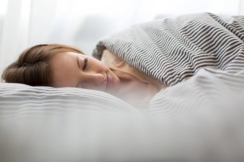 woman in bed sleeping with a prosthetic eye